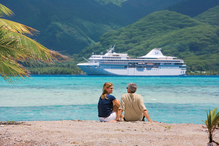 Stelletje op het strand voor schip Paul Gauguin Cruises